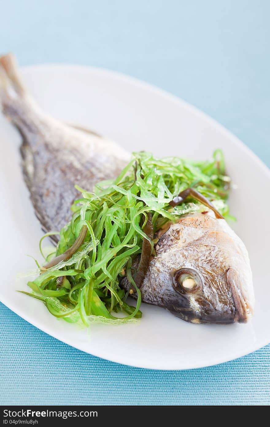 Grilled sea bream and seaweed salad, selective focus