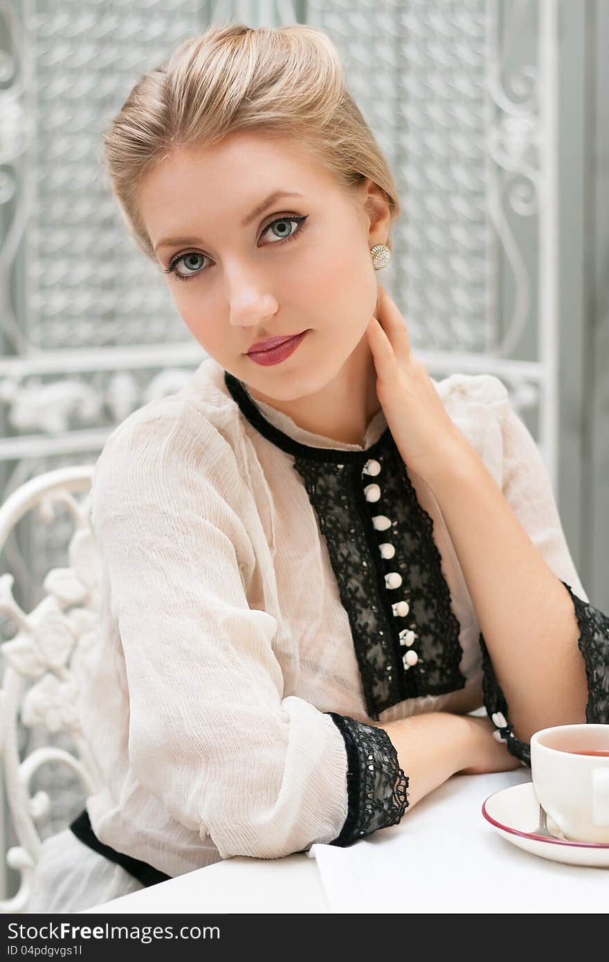 Young Beautiful Woman Sits At Table