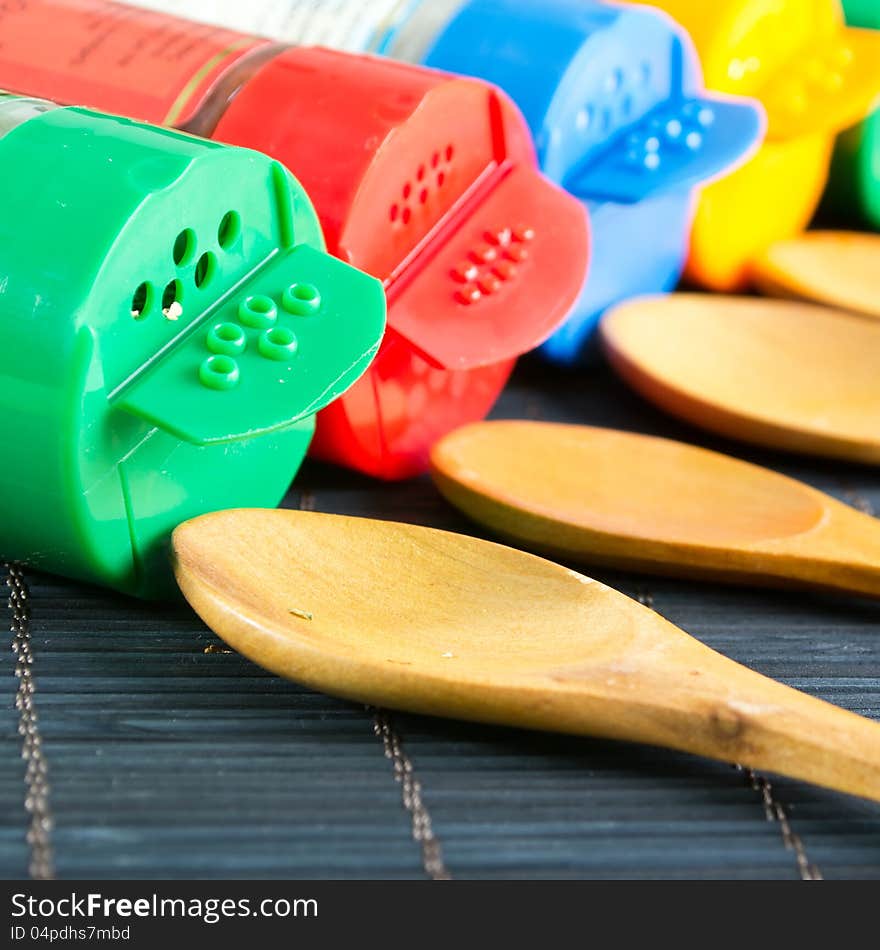 Wooden spoons and  bottles with spices,close up