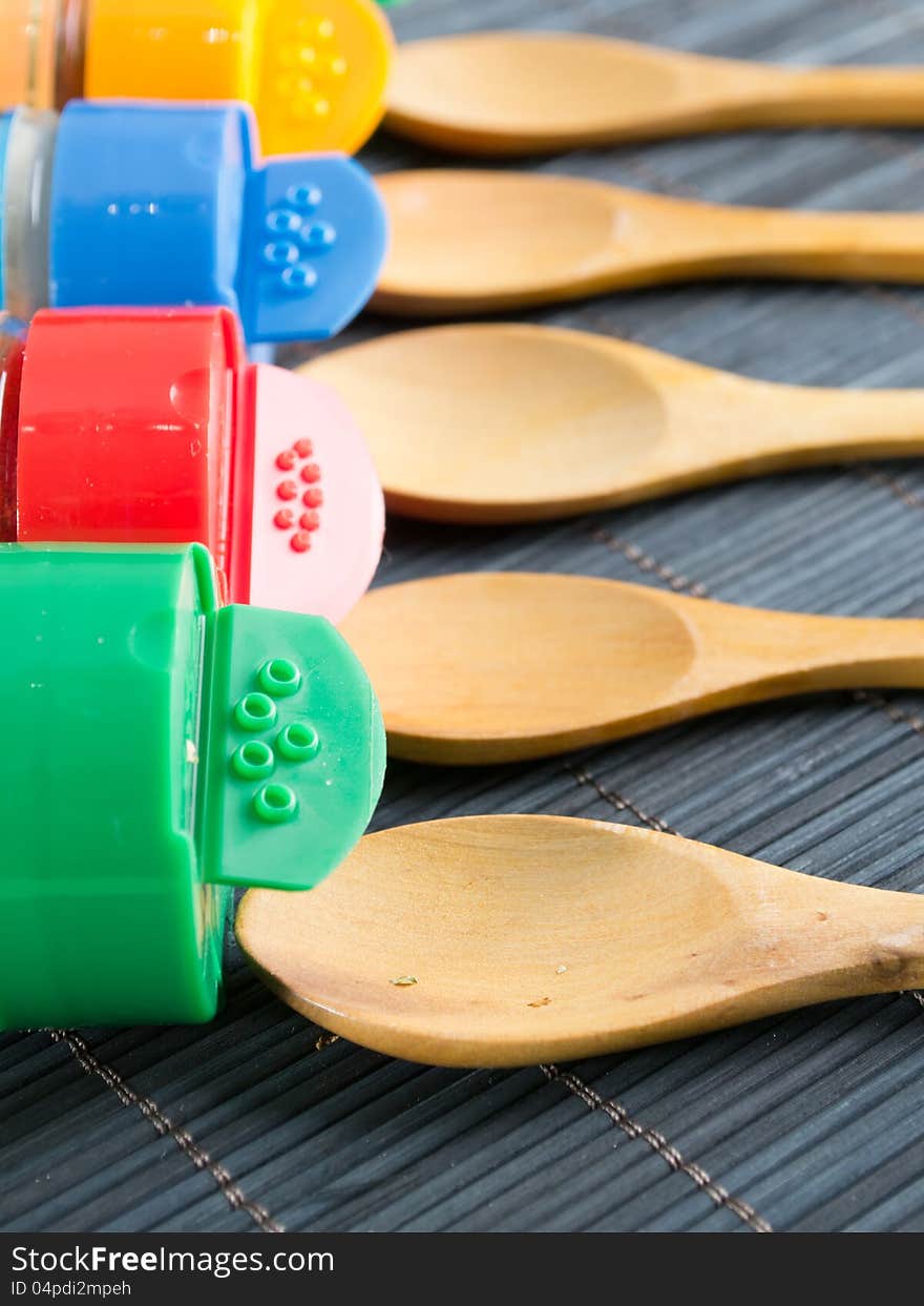 Wooden spoons and  bottles with spices,close up