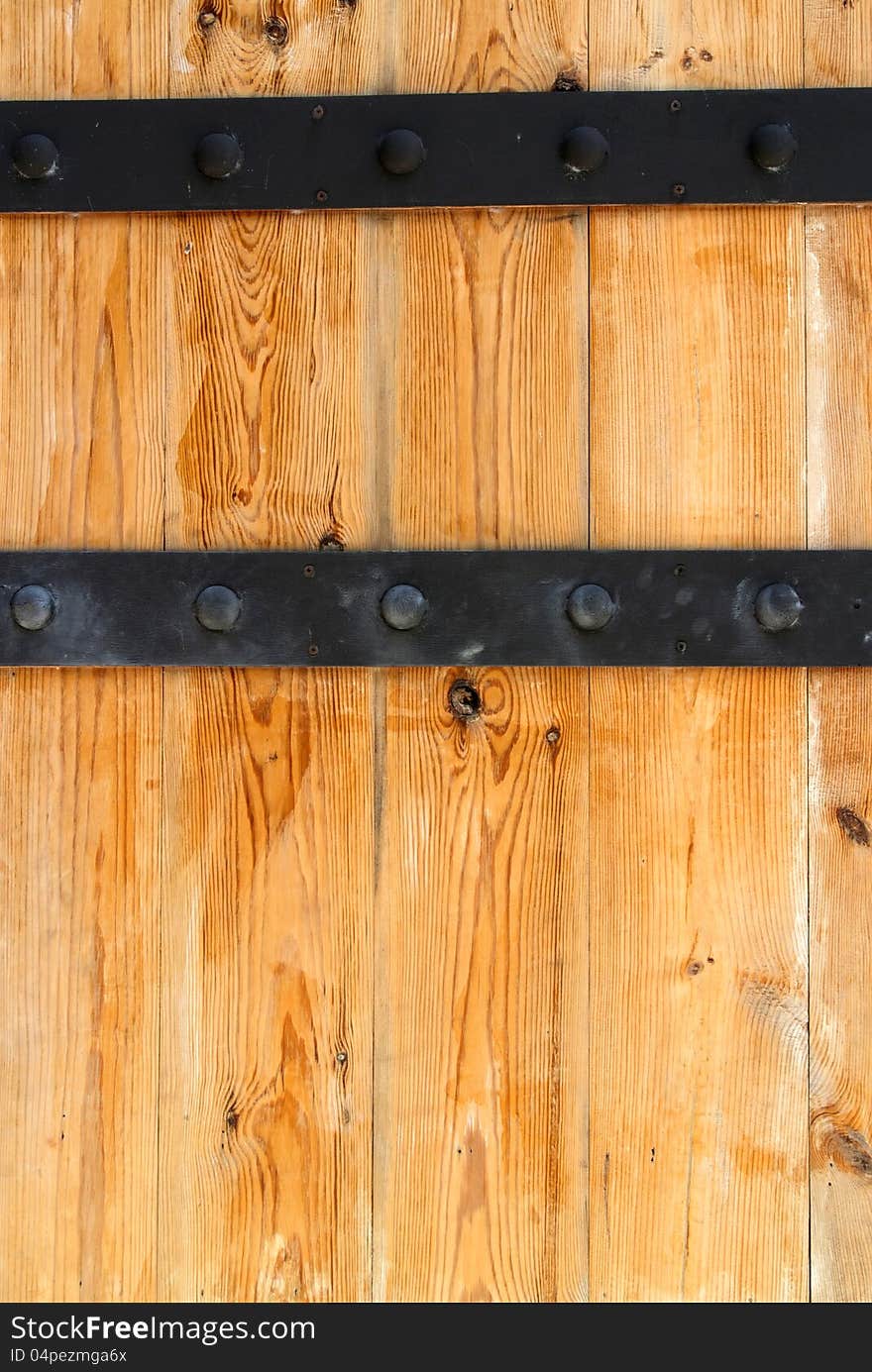 Detail of wooden door and black metal hinge. Detail of wooden door and black metal hinge