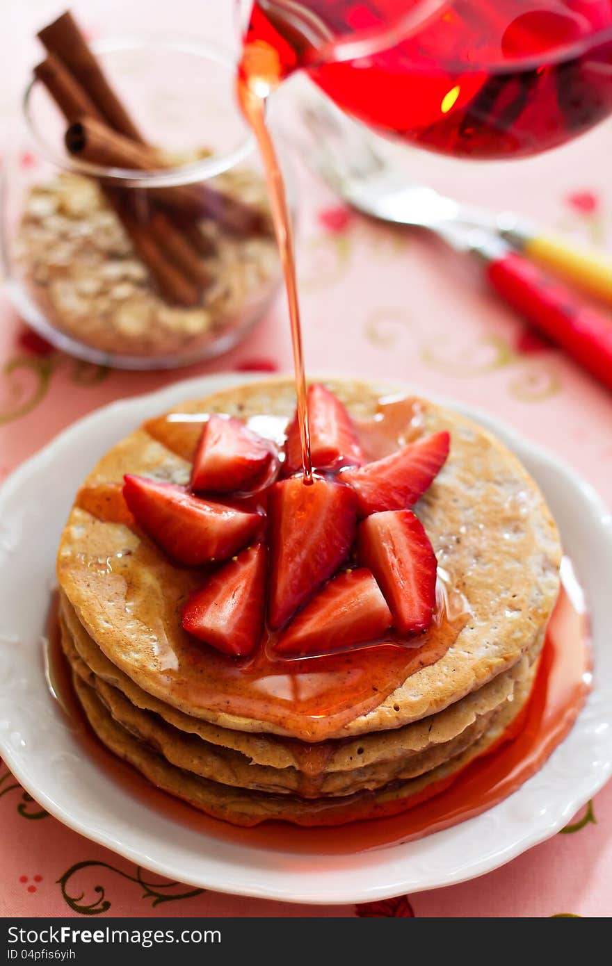 A stack of pancakes with fresh strawberries