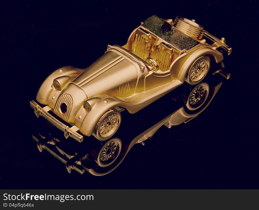 Gold little toy car on black. Gold little toy car on black