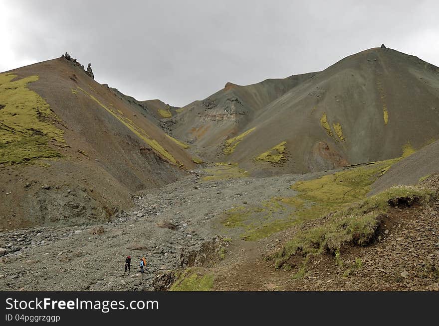 Severe volcanic landscape and hikers at highland area in Iceland. Severe volcanic landscape and hikers at highland area in Iceland.