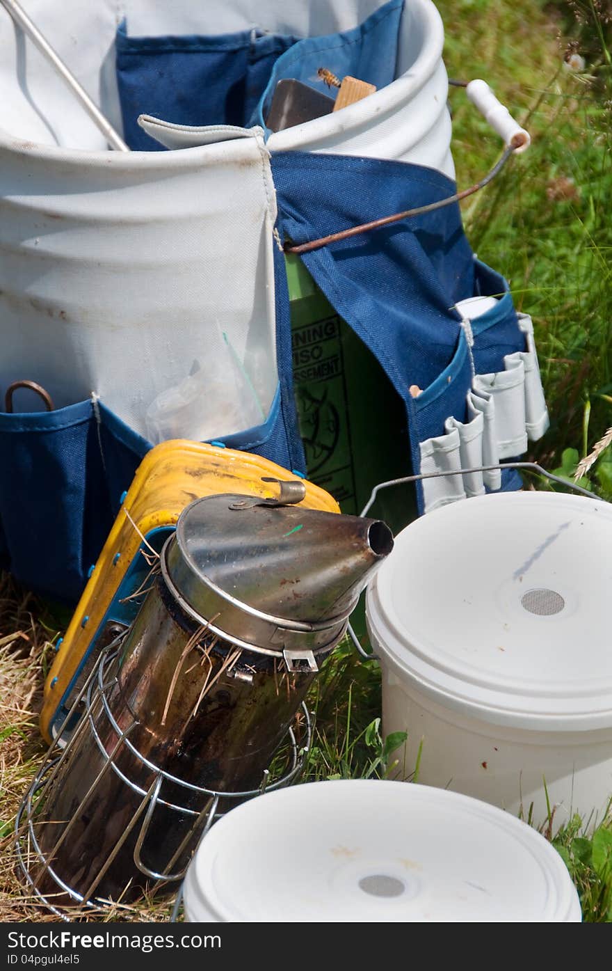 Beekeeping equipment awaits use including a beehive smoker and pails for collecting honey. Beekeeping equipment awaits use including a beehive smoker and pails for collecting honey.