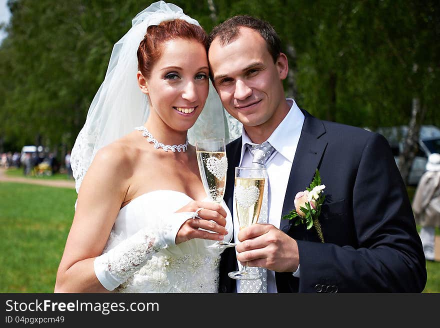 Bride and groom with champagne glasses on wedding walk