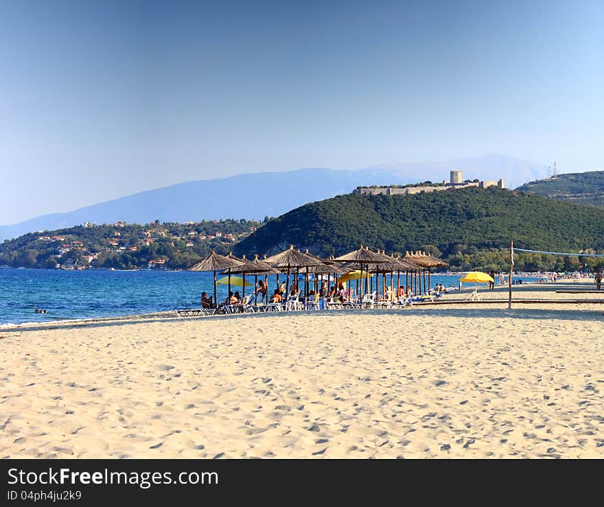 View of the Platamon beach with his golden sand. In the back the famous Platamon Castle. HDR Image. View of the Platamon beach with his golden sand. In the back the famous Platamon Castle. HDR Image