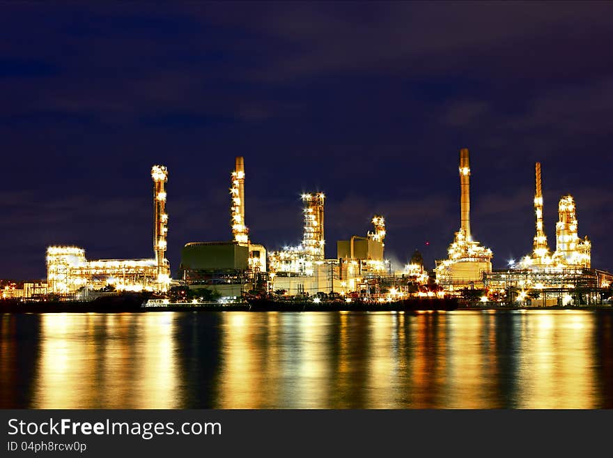 Oil refinery factory with reflection on the river with blue sky. Oil refinery factory with reflection on the river with blue sky.