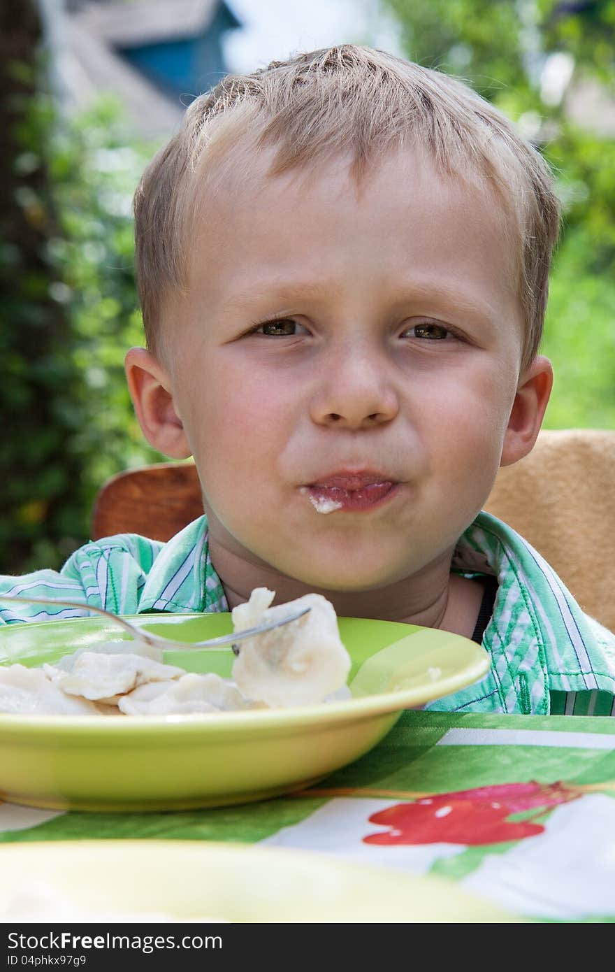 Boy eats breakfast outdoors