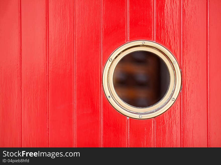 Decorative picture of red painted wood panels (entrance door) with a bull's eye. Decorative picture of red painted wood panels (entrance door) with a bull's eye