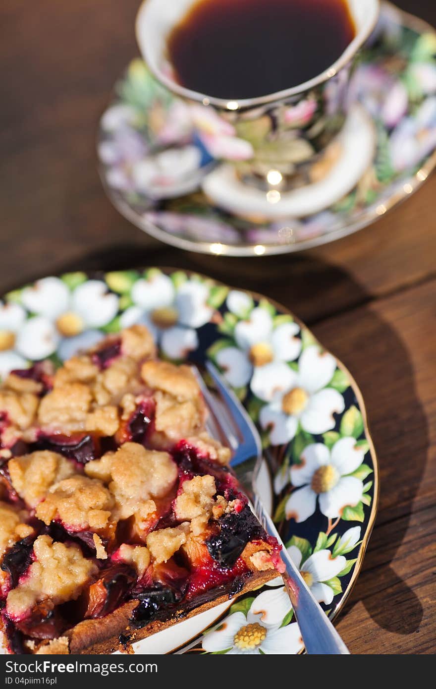 Plum cake and coffee on a wooden table