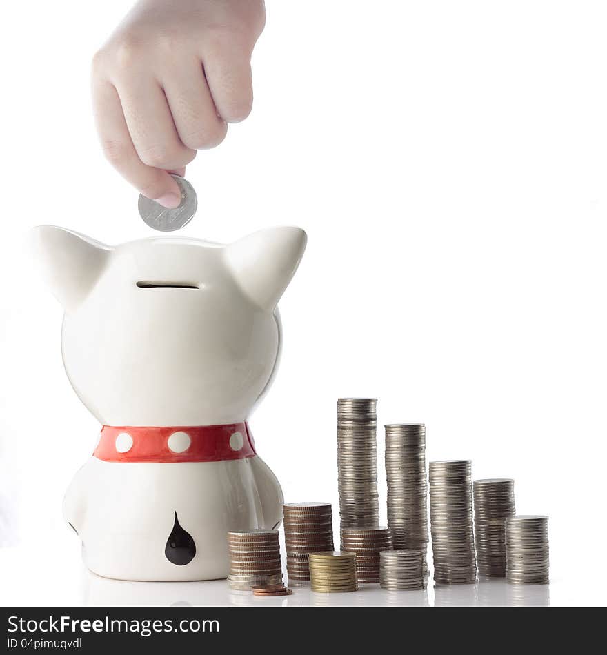 A hand safing coin in piggy bank on white background. A hand safing coin in piggy bank on white background