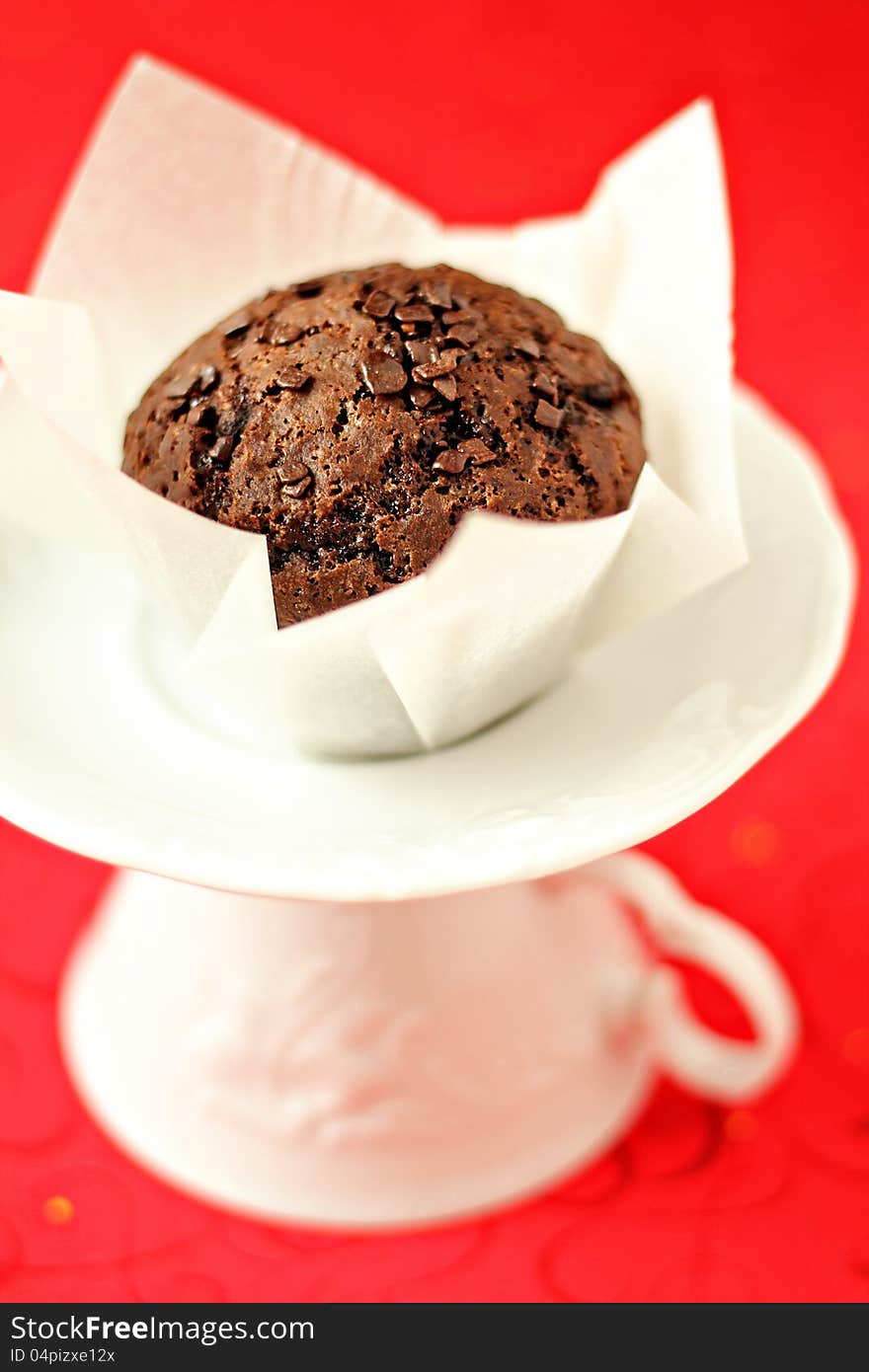 Vegan chocolate muffin on a white saucer