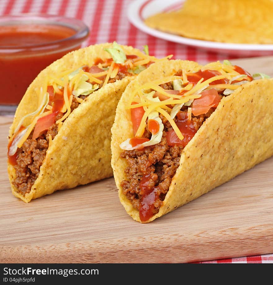 Two beef tacos with lettuce, tomato and sauce