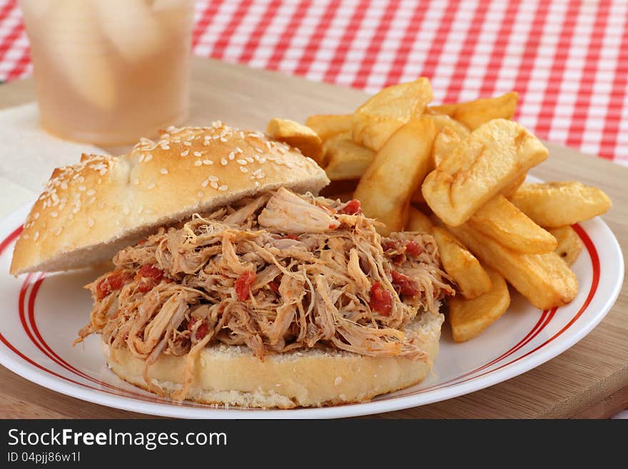 Pullled pork sandwich with french fries on a plate. Pullled pork sandwich with french fries on a plate