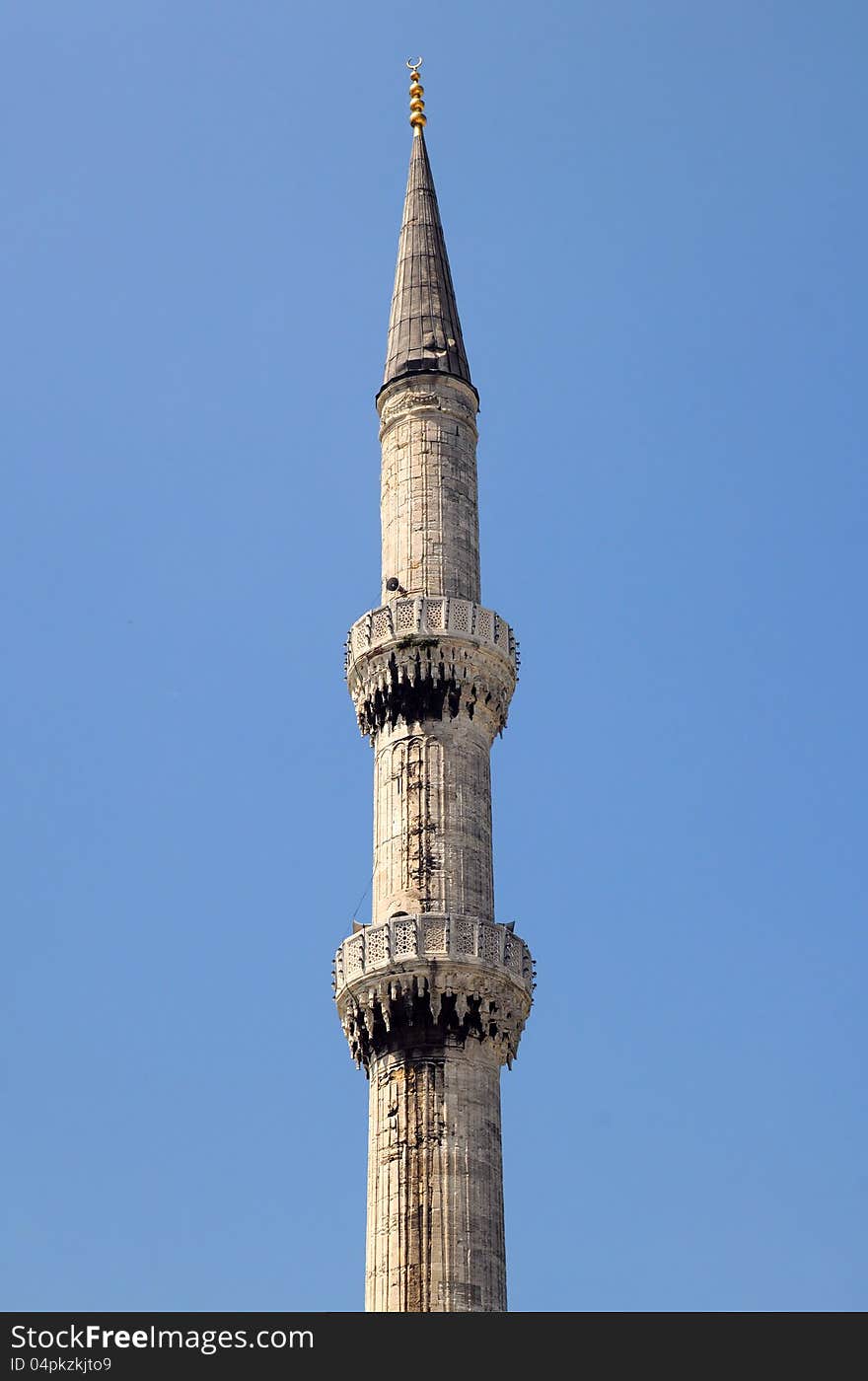 Fragment of one of the Blue Mosque minarets against blue sky background in Istanbul, Turkey