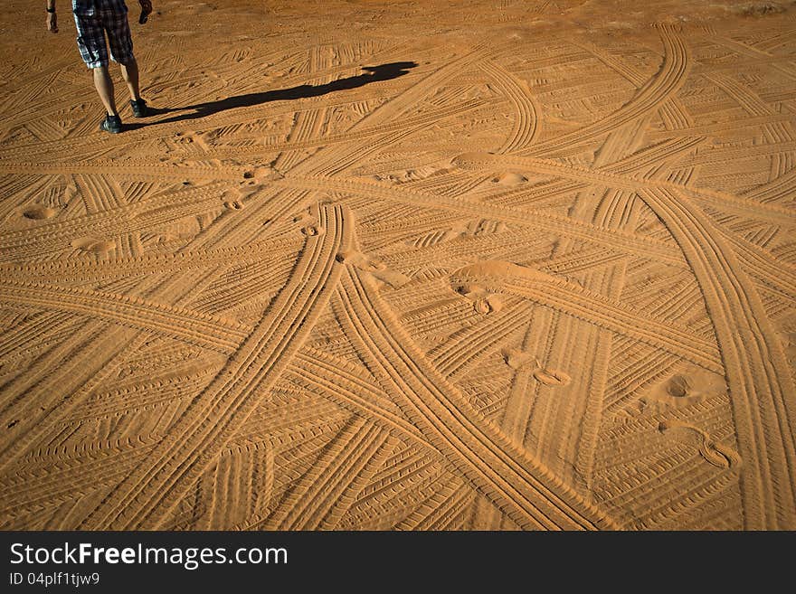 A series of traces of feet and tires in the desert. A series of traces of feet and tires in the desert