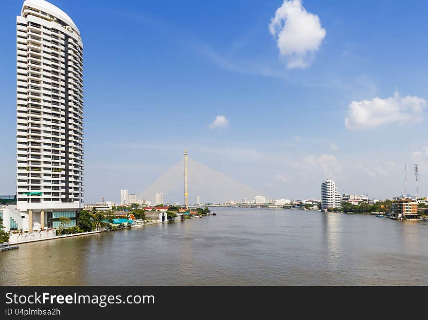 Chaopraya river waterfront in Bangkok with Rama VIII bridge in background, Thailand