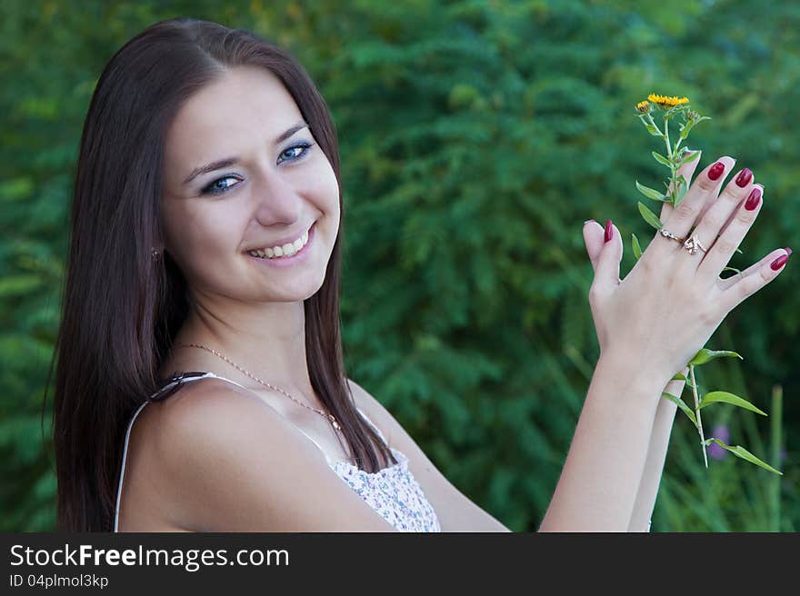 Portrait attractive young woman with flower outdoors