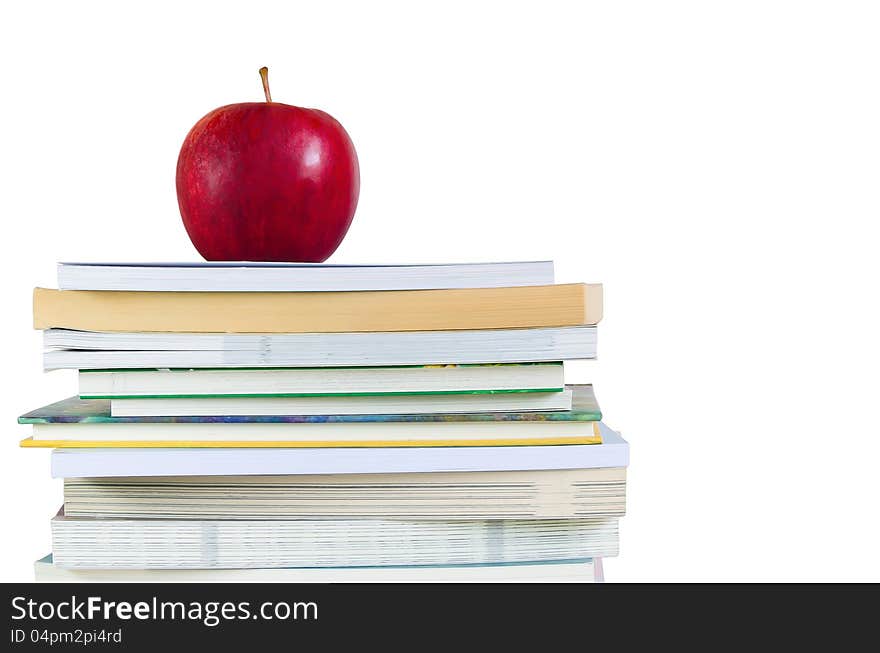 Book stack with fresh red apple on top in white background