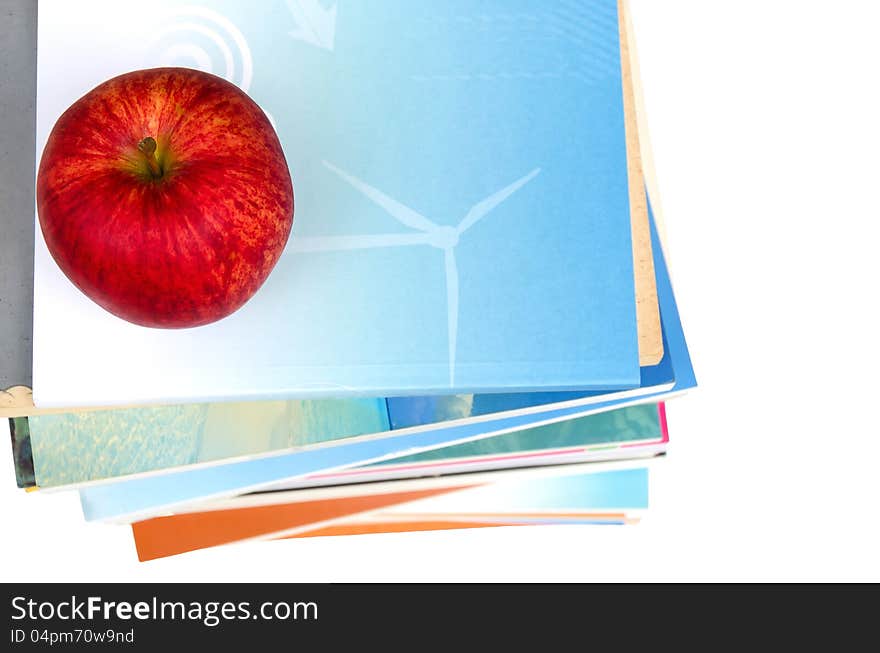 One red apple on top of book stack in white background