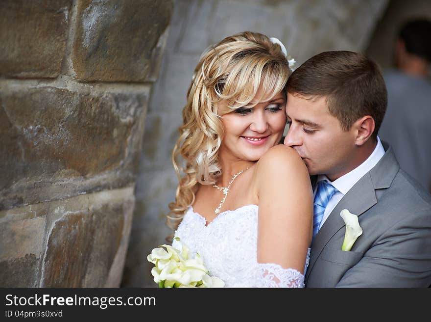 Gentle kiss on the shoulder on wedding day