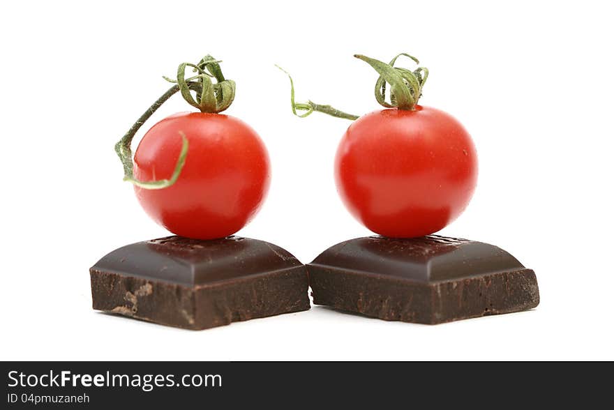 Fresh tomatoe on piece of dark chocolate presented on white. Fresh tomatoe on piece of dark chocolate presented on white