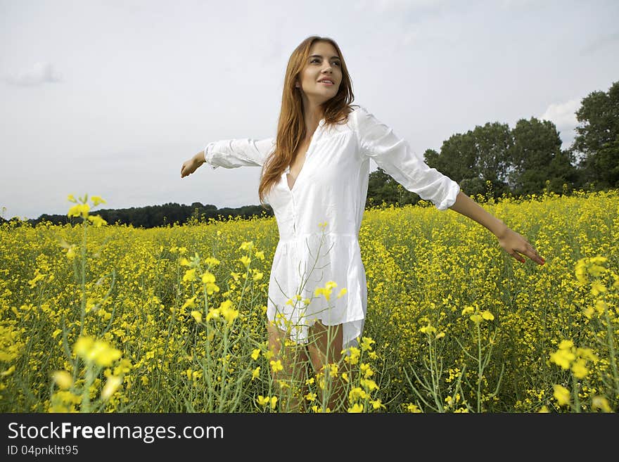 Brunette woman in a yellow flowers field