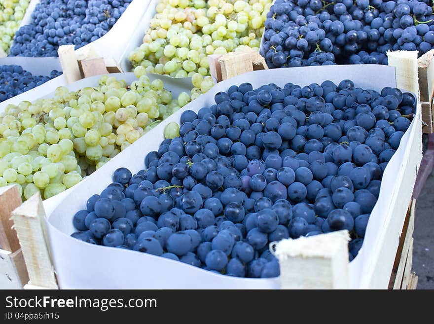 Organic grapes in crates on market stalls