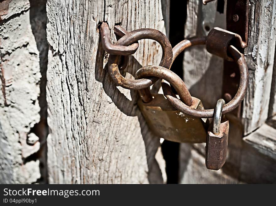 Rusty padlock attached to wooden door