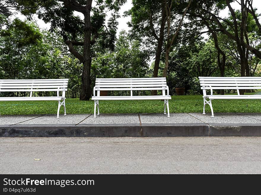 Three white chairs in the garden.