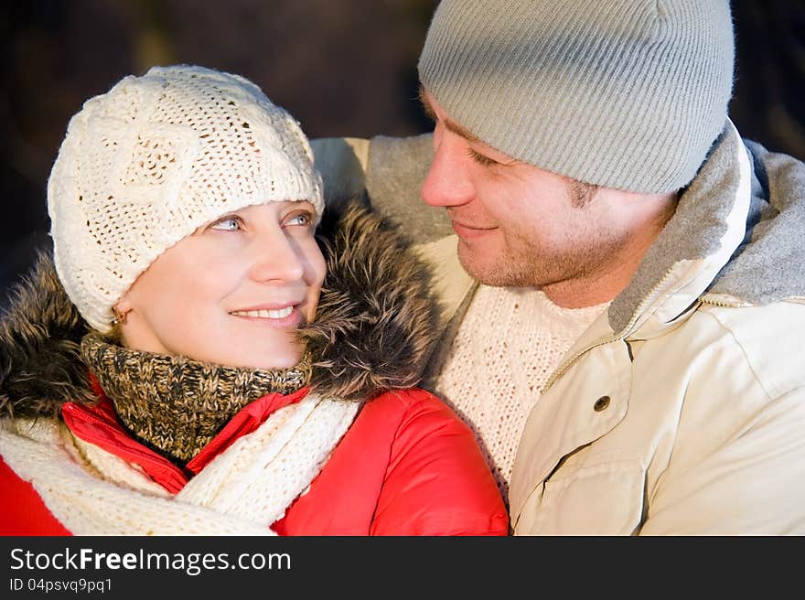 Portrait of women embracing her boyfriend in the winter park. Portrait of women embracing her boyfriend in the winter park.