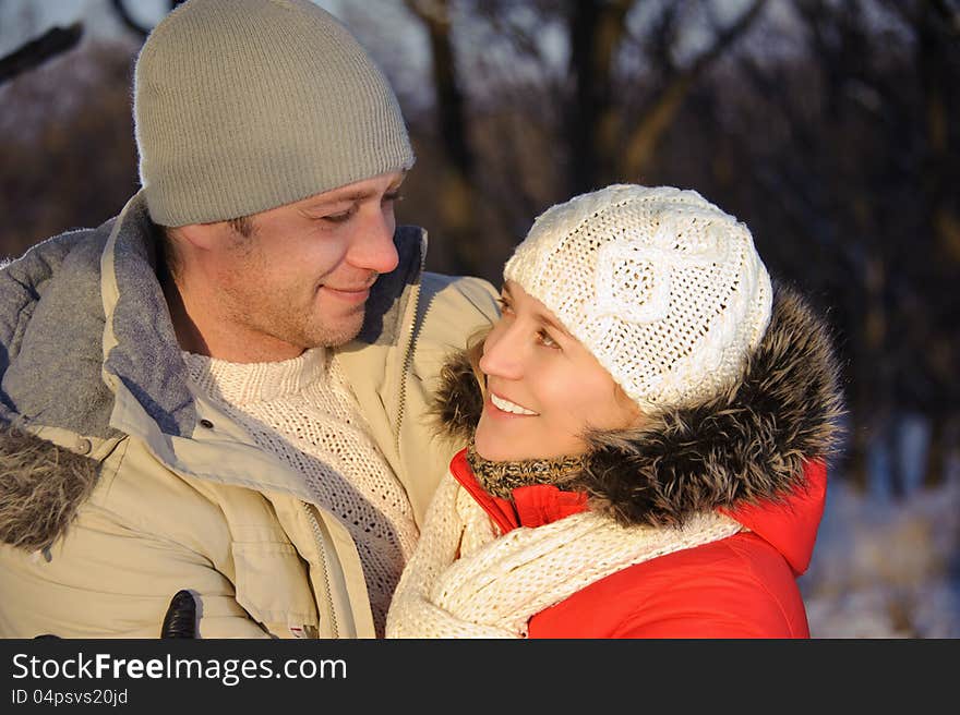 Portrait of women embracing her boyfriend in the winter park. Portrait of women embracing her boyfriend in the winter park.