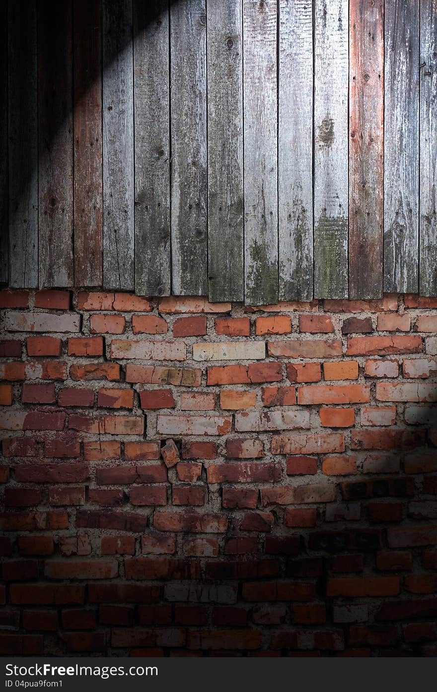 A spotlight on a dark grungy wood and brick wall. A spotlight on a dark grungy wood and brick wall