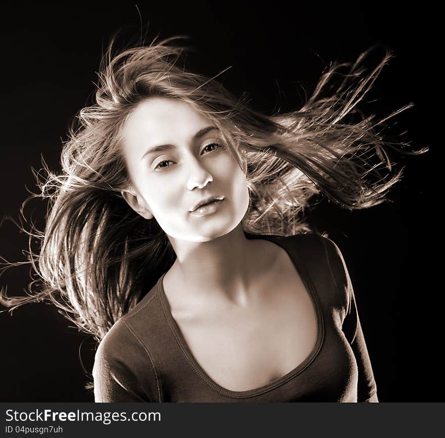 Portrait of a beautiful young woman with hair flying