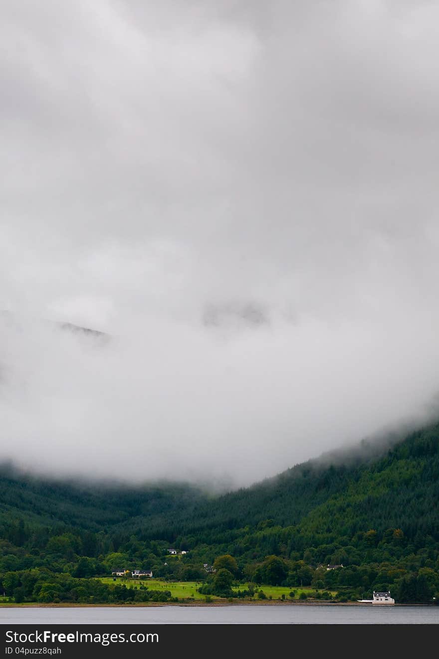 Landscape for scotland at glencoe area, Fort williams, Scottish Highlands. Mountain hidden in fog with cottage house at the base. Landscape for scotland at glencoe area, Fort williams, Scottish Highlands. Mountain hidden in fog with cottage house at the base.