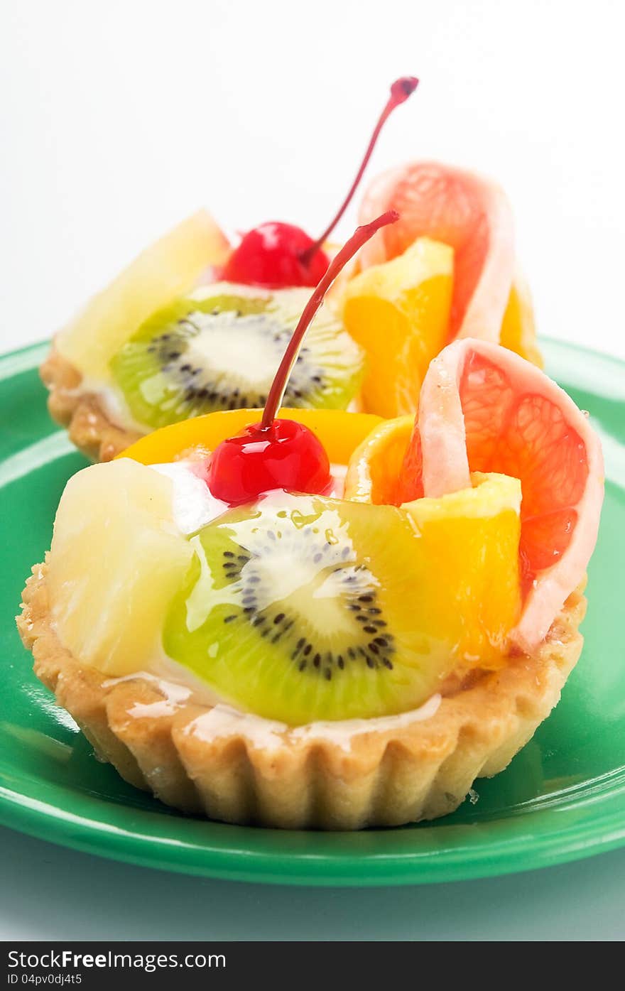 Cupcake with fruits on the green plate.