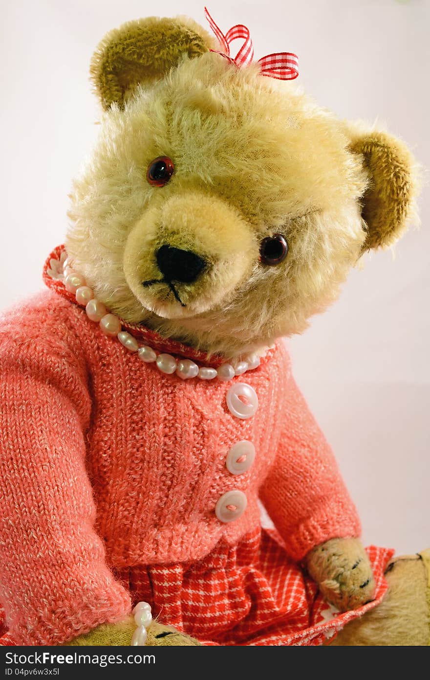 An old teddy bear toy from the 60s with sawdust stuffing and homemade clothes. An old teddy bear toy from the 60s with sawdust stuffing and homemade clothes