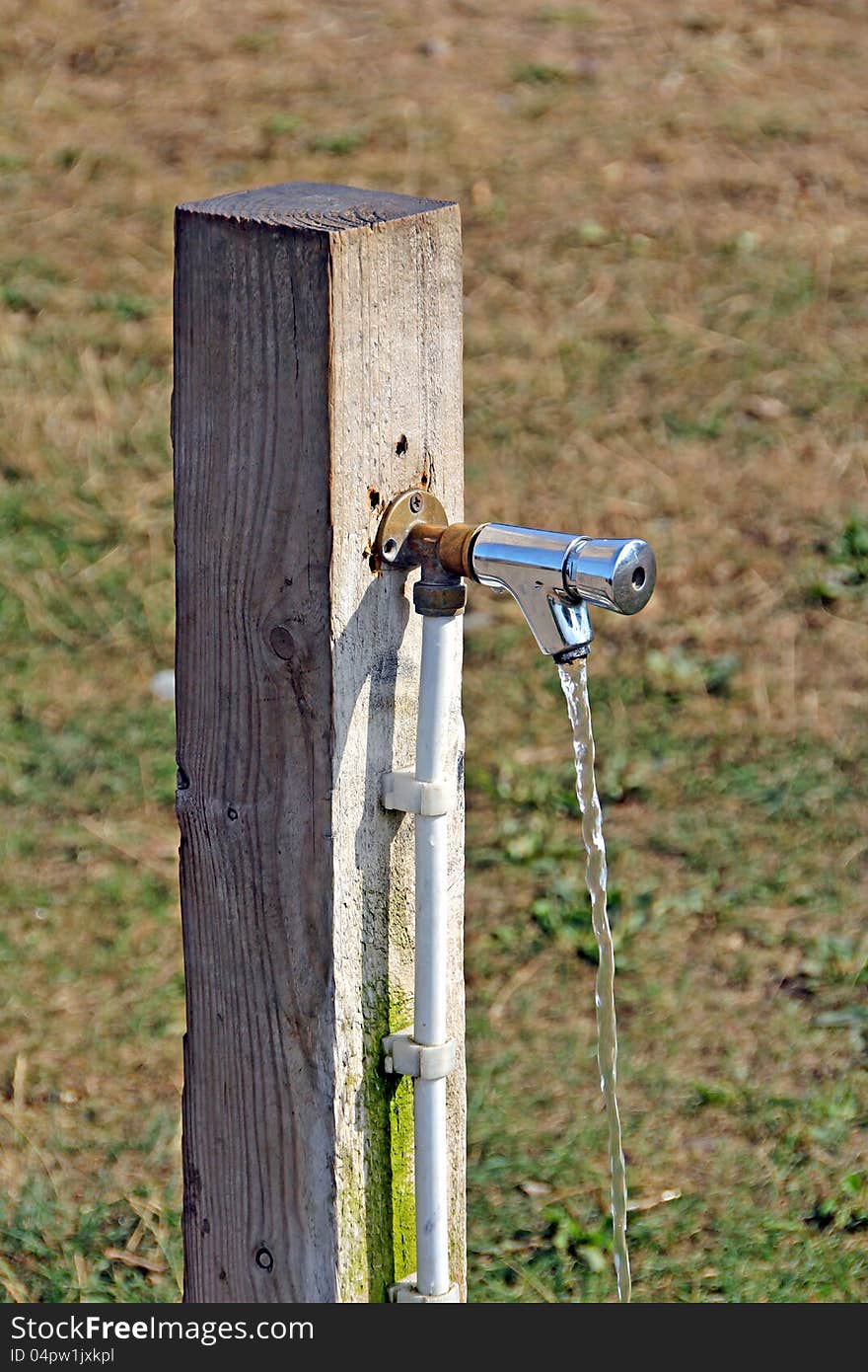 Photo of running water coming from a standpipe attached to a wooden post. Photo of running water coming from a standpipe attached to a wooden post.