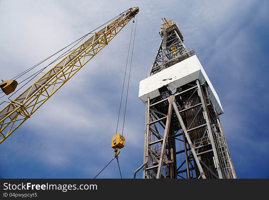 Derick of drilling rig with the yellow rig crane