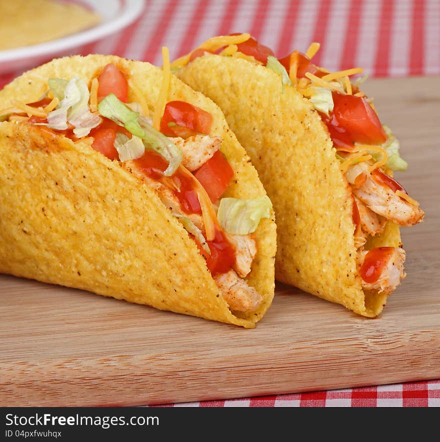 Two chicken tacos with tomato, lettuce, cheese and sauce. Two chicken tacos with tomato, lettuce, cheese and sauce