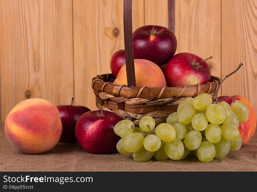 Ripe grapes, peach, apple in the basket. Ripe grapes, peach, apple in the basket