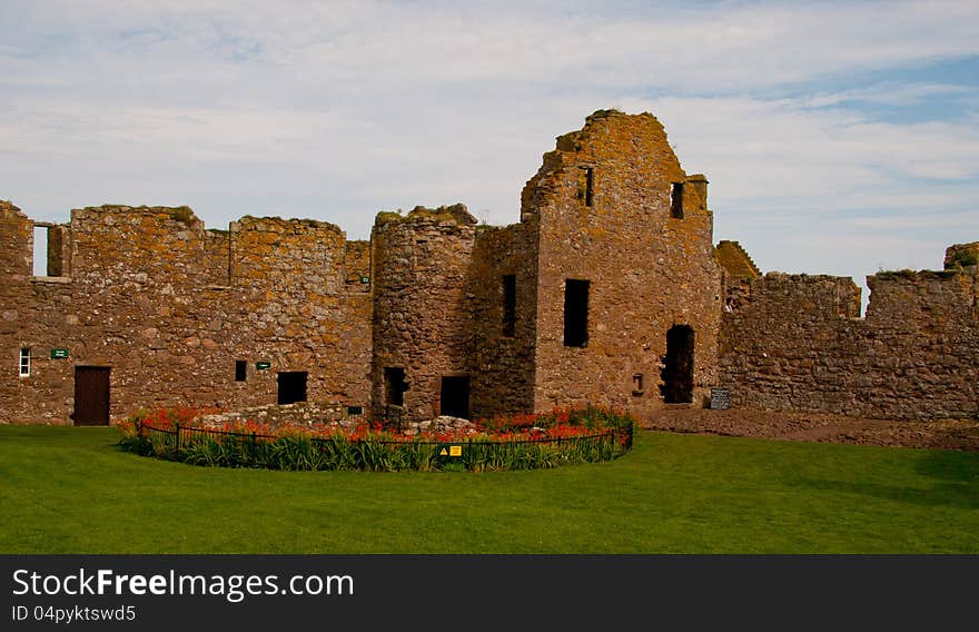 Well and Castle Buildings at Dunnottar Castle, Stonehaven, Aberdeenshire, Scotlaqnd. U.K. Dunnottar Castle, &#x22;fort on the shelving slope&#x22;&#x29; is a ruined medieval fortress located upon a rocky headland on the northeastern coast of Scotland, about 2 miles &#x28;3.2 km&#x29; south of Stonehaven. The surviving buildings are largely of the 15th and 16th centuries, but the site is believed to have been fortified in the Early Middle Ages. Dunnottar has played a prominent role in the history of Scotland through to the 18th-century Jacobite risings because of its strategic location and defensive strength. Dunnottar is best known as the place where the Honours of Scotland, the Scottish crown jewels, were hidden from Oliver Cromwell&#x27;s invading army in the 17th century. The property of the Keiths from the 14th century, and the seat of the Earl Marischal, Dunnottar declined after the last Earl forfeited his titles by taking part in the Jacobite rebellion of 1715. The castle was restored in the 20th century and is now open to the public. The ruins of the castle are spread over 1.4 hectares &#x28;3.5 acres&#x29;, surrounded by steep cliffs that drop to the North Sea, 160 feet &#x28;49 m&#x29; below. A narrow strip of land joins the headland to the mainland, along which a steep path leads up to the gatehouse. The various buildings within the castle include the 14th-century tower house as well as the 16th-century palace. Dunnottar Castle is a scheduled monument, and twelve. Well and Castle Buildings at Dunnottar Castle, Stonehaven, Aberdeenshire, Scotlaqnd. U.K. Dunnottar Castle, &#x22;fort on the shelving slope&#x22;&#x29; is a ruined medieval fortress located upon a rocky headland on the northeastern coast of Scotland, about 2 miles &#x28;3.2 km&#x29; south of Stonehaven. The surviving buildings are largely of the 15th and 16th centuries, but the site is believed to have been fortified in the Early Middle Ages. Dunnottar has played a prominent role in the history of Scotland through to the 18th-century Jacobite risings because of its strategic location and defensive strength. Dunnottar is best known as the place where the Honours of Scotland, the Scottish crown jewels, were hidden from Oliver Cromwell&#x27;s invading army in the 17th century. The property of the Keiths from the 14th century, and the seat of the Earl Marischal, Dunnottar declined after the last Earl forfeited his titles by taking part in the Jacobite rebellion of 1715. The castle was restored in the 20th century and is now open to the public. The ruins of the castle are spread over 1.4 hectares &#x28;3.5 acres&#x29;, surrounded by steep cliffs that drop to the North Sea, 160 feet &#x28;49 m&#x29; below. A narrow strip of land joins the headland to the mainland, along which a steep path leads up to the gatehouse. The various buildings within the castle include the 14th-century tower house as well as the 16th-century palace. Dunnottar Castle is a scheduled monument, and twelve