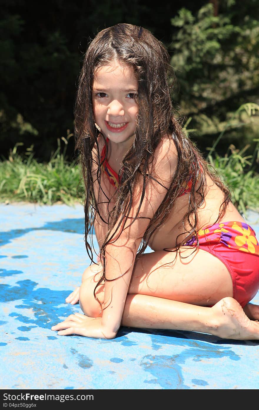 Smiling little girl sitting by the pool. Smiling little girl sitting by the pool