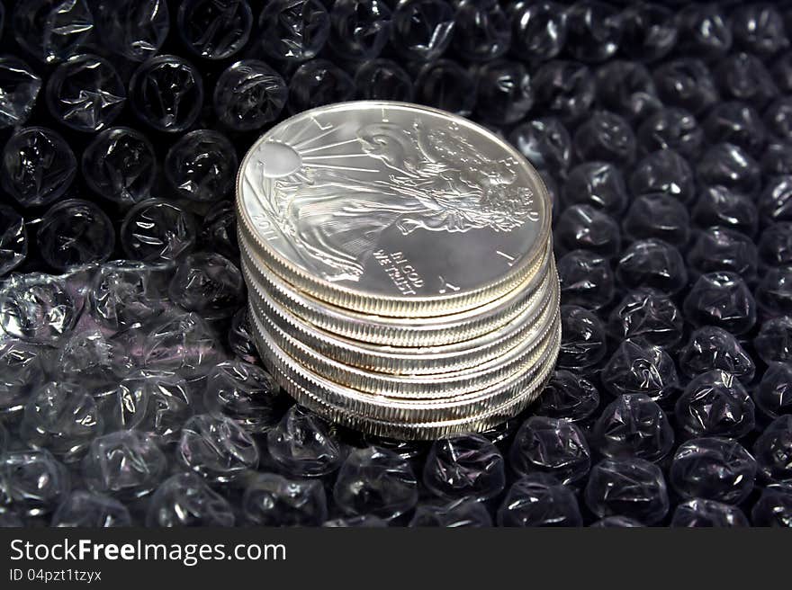 Stack of silver dollars protected by bubble wrap. Stack of silver dollars protected by bubble wrap