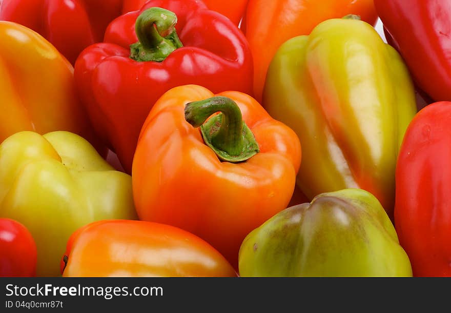 Red, Yellow, Orange and Green Bell Peppers Background close up