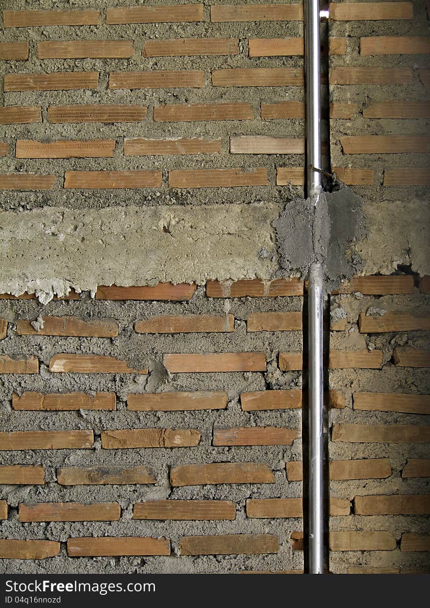 Brick wall with metal pipe.