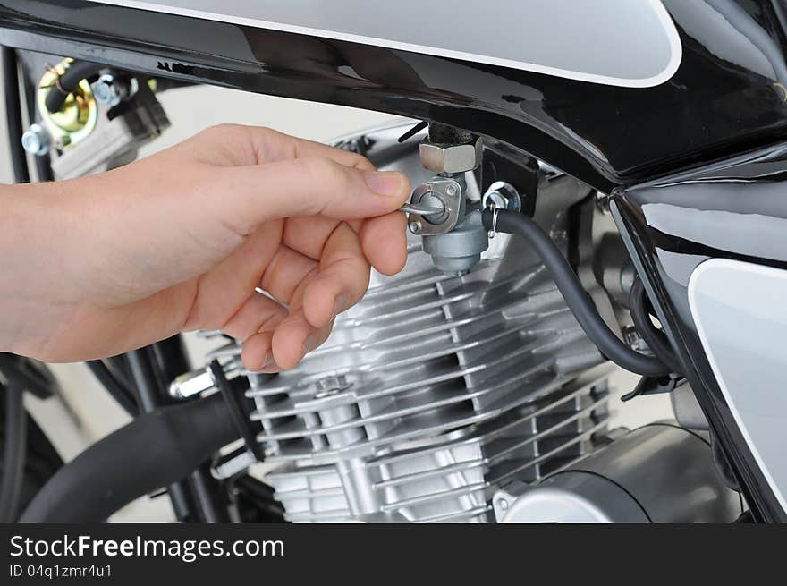 Mechanic checking the petrol tap on a motorcycle