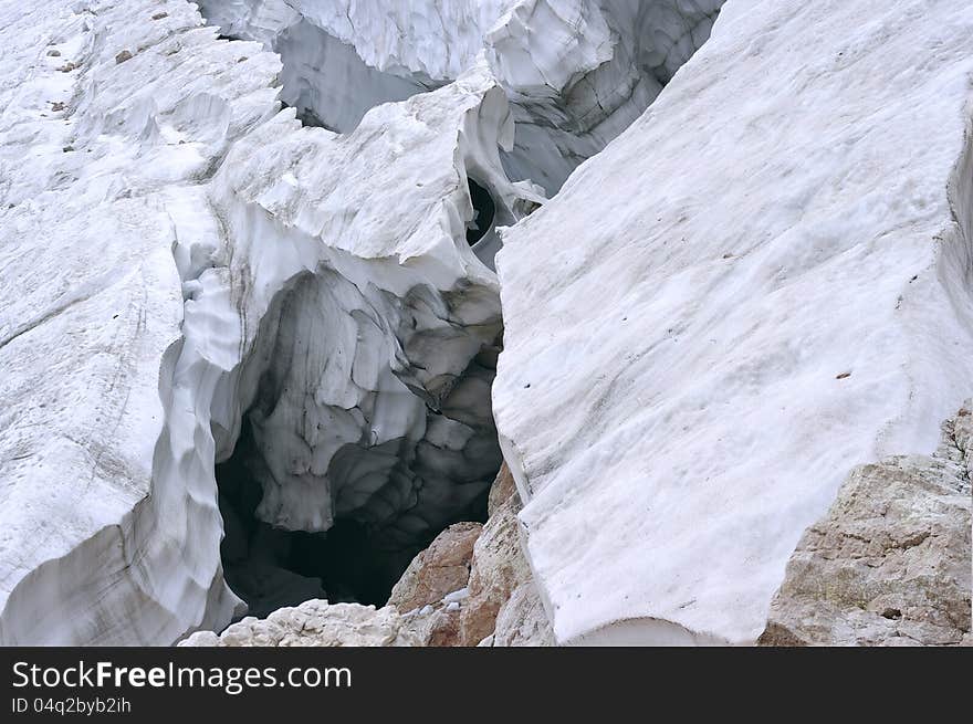 Deep crack in the glacier in the mountains