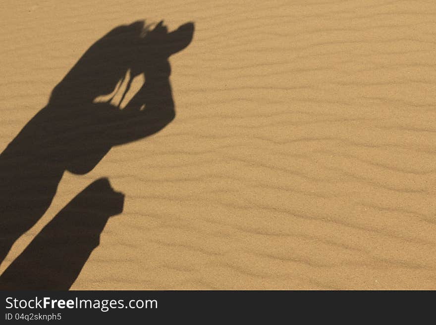 A shadow of a photographer shooting in the desert